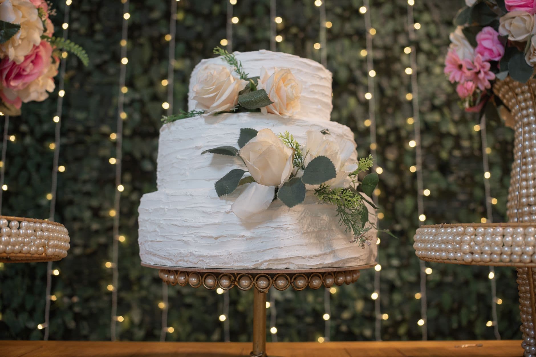 bolo de casamento branco de três andares sobre uma mesa