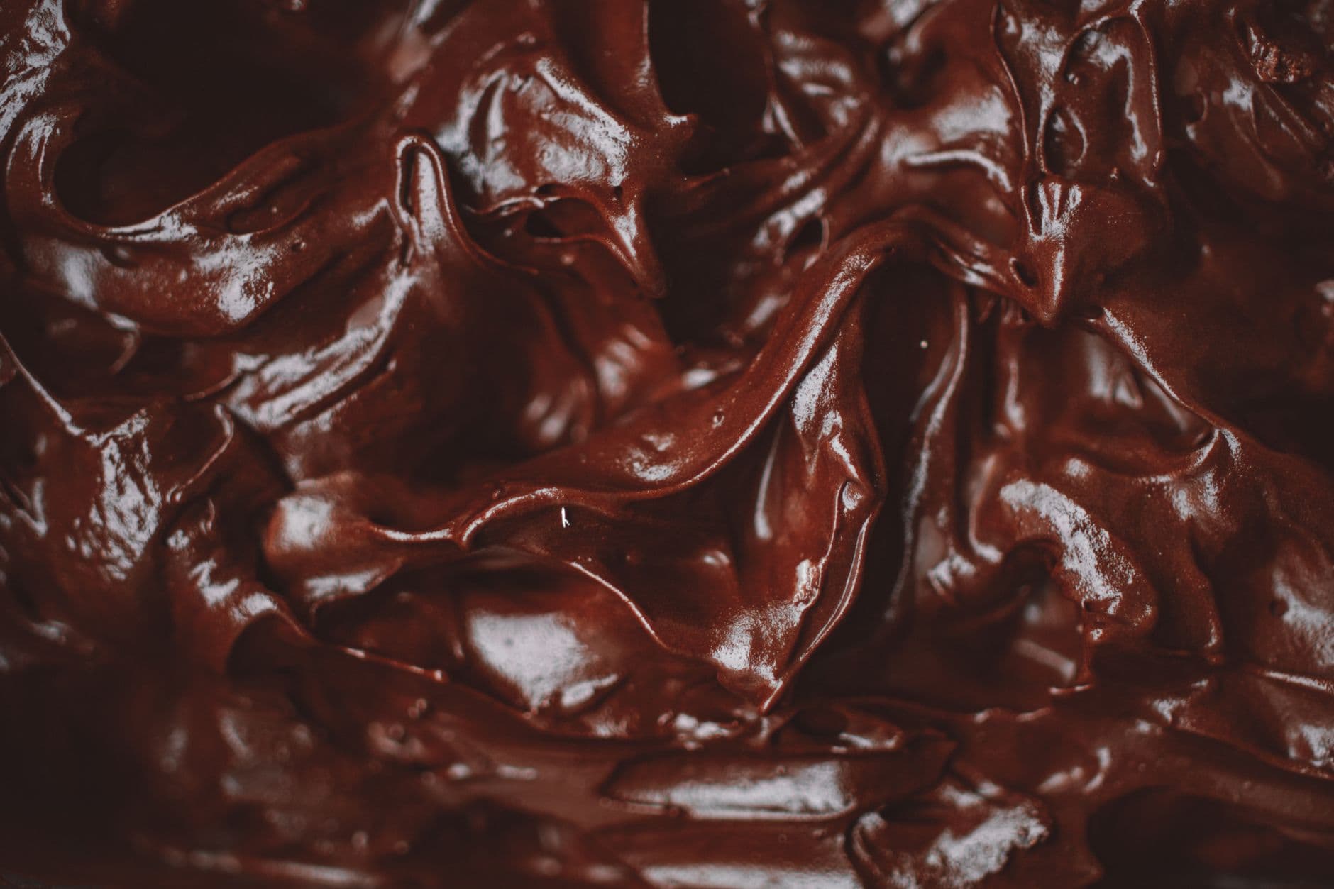 Ganache de chocolate sendo despejada de uma tigela