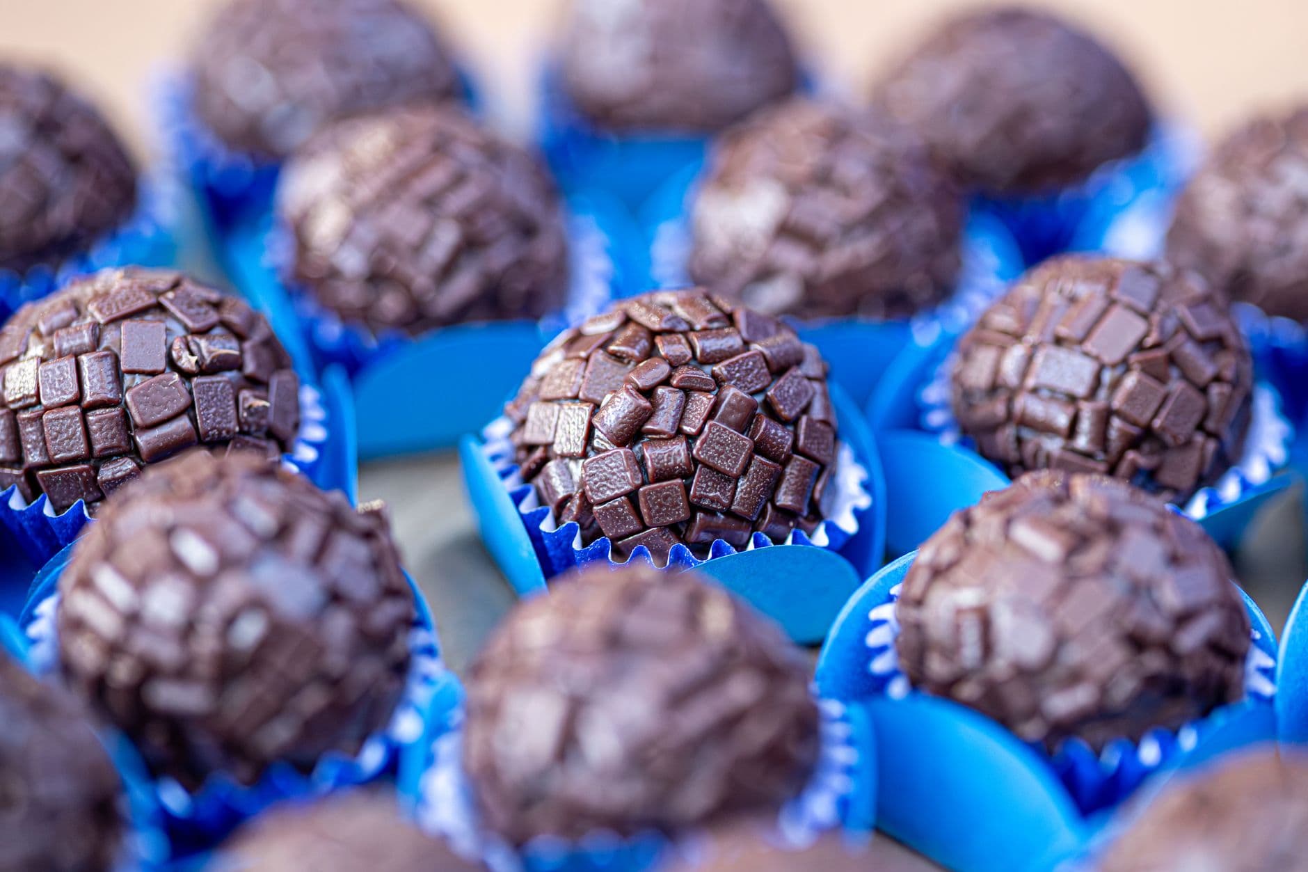 brigadeiros enrolados cobertos de granulado sobre uma bandeja